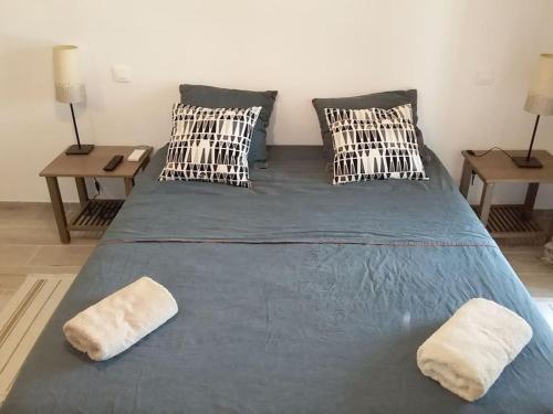 - un grand lit bleu avec 2 oreillers et 2 tables dans l'établissement Villa-piscine privative en Haute Provence, à Oraison