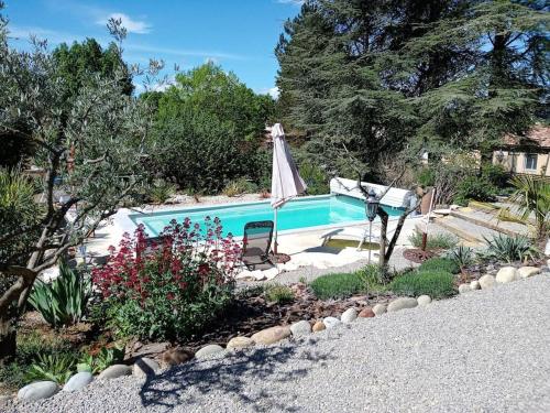 - une piscine avec une chaise et un parasol dans l'établissement Villa-piscine privative en Haute Provence, à Oraison