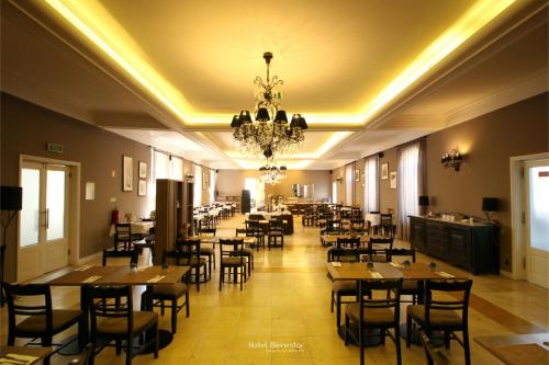 a restaurant with tables and chairs and a chandelier at Hotel Bienestar Termas De Vizela in Vizela
