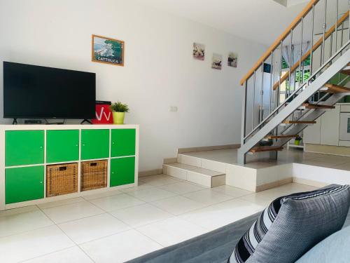 a living room with a tv and a staircase at El cortijo Bungalow Playa las Americas in Playa de las Americas