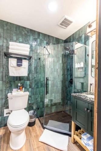 a bathroom with a toilet and a glass shower at Tall Pines a cozy 1 bedroom Tiny Cabin in Leavenworth