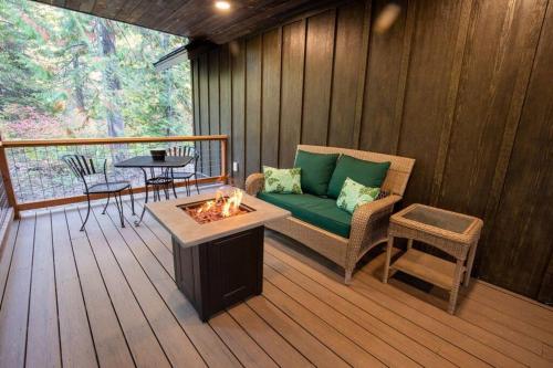 a screened in porch with a couch and a fire pit at Tall Pines a cozy 1 bedroom Tiny Cabin in Leavenworth