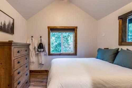 a bedroom with a bed and a dresser and a window at Tall Pines a cozy 1 bedroom Tiny Cabin in Leavenworth