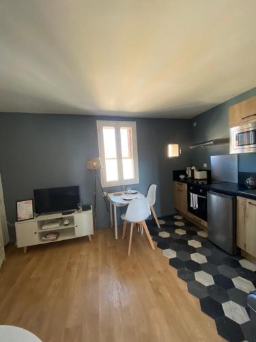une cuisine avec une table et une table ainsi qu'une salle à manger dans l'établissement Appartement Cosy proche gare, à Narbonne