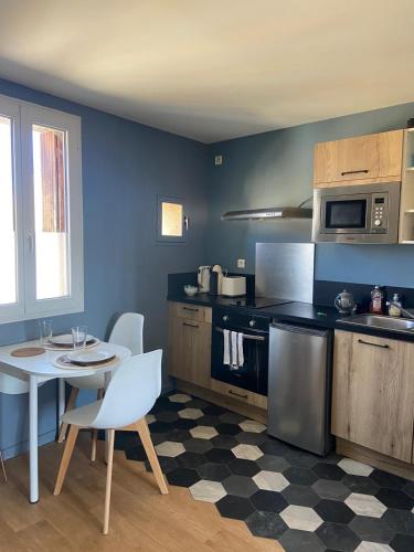 une cuisine avec une table et une table ainsi qu'une cuisine avec dans l'établissement Appartement Cosy proche gare, à Narbonne