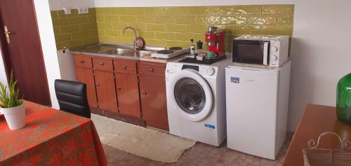 a kitchen with a washing machine and a sink at Cantinho dos moinhos in Figueira da Foz