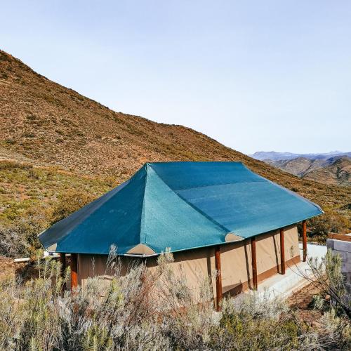 a building with a blue tarp on top of a hill at Aloeron at Patatsfontein Stay in Montagu