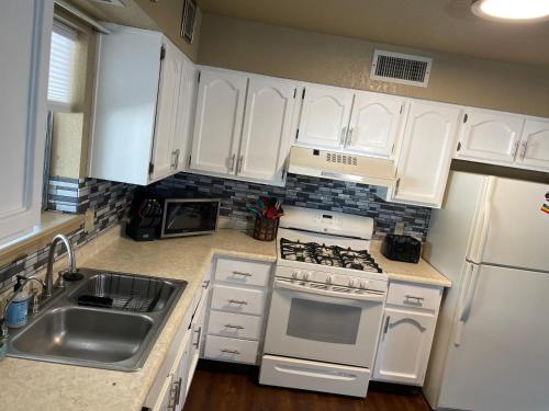 a kitchen with white cabinets and a stove and a sink at All season vacation home! in Cottonwood
