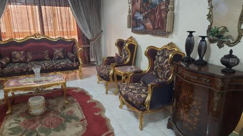 een woonkamer met stoelen, een bank en een tafel bij العشرين فيصل الجيزة in Caïro