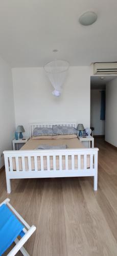 a large white bed in a room with wooden floors at Superb large private villa with pool in Prainha