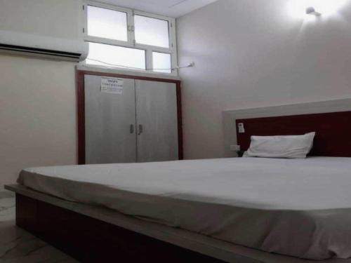 ein Schlafzimmer mit einem großen Bett mit Fenster in der Unterkunft Hotel O G Hotel Happy Home in Aligarh