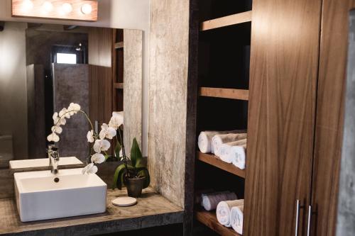 a bathroom with a sink and a mirror and towels at DISTRITO 88 - Hotel Boutique Only Adults in Sayulita