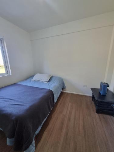 1 dormitorio con 1 cama y suelo de madera en Mitre 1400 Apartamentos en Monte Grande