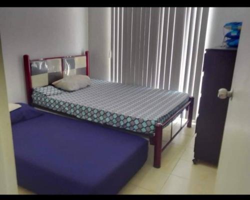 a small bedroom with a bed and a blue mattress at Departamento ACAPULCO PROMOCIÓN in Aguacatillo