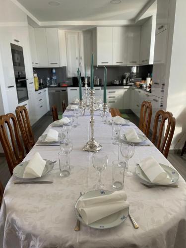 a dining room table with a white table cloth and glasses at Casa da Celeste in Vale do Pereiro
