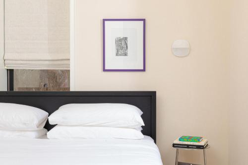 a bed with white pillows and a picture on the wall at YOWIE Hotel in Philadelphia