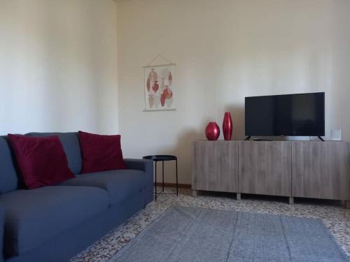 Una sala de estar con un sofá azul y un televisor de pantalla plana. en Casa Clelia, en Ponte Buggianese