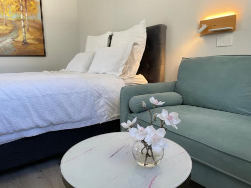 un soggiorno con divano e tavolo con vaso di fiori di 66 Express luxury apartment in New Market Our apartments has Self-checkin System ad Auckland