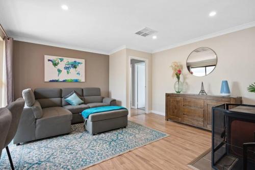 a living room with a couch and a tv at Spacious 3BR house with a cosy log fire & luxury spa bath in Kalgoorlie