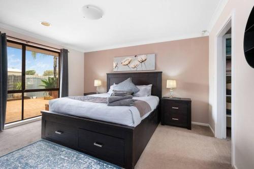 a bedroom with a large bed and a large window at Jarvis Place Spacious 3BR house with a cosy log fire & luxury spa bath in Kalgoorlie