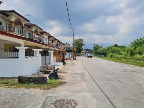 an empty street with a building and a manhole at Air-home M1 Simpang near Aulong Econsave, 4BR, 10pax, Netflix in Simpang