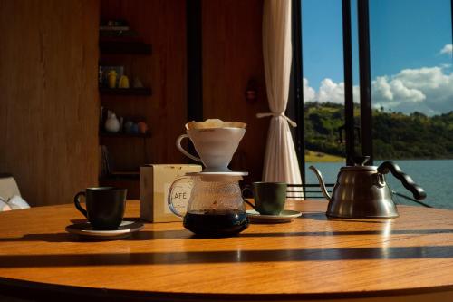 una mesa con dos tazas y una cafetera en ella en Altar Flutuante em Joanópolis, en Joanópolis