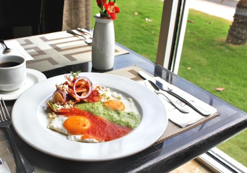 a plate of food on a table with a cup of coffee at Hilton Garden Inn Tuxtla Gutierrez in Tuxtla Gutiérrez