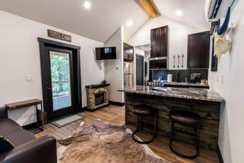 a kitchen with a bar with stools and a fireplace at Wilderness Lodge 1 bedroom cabin in the woods at Lake Wenatchee in Leavenworth