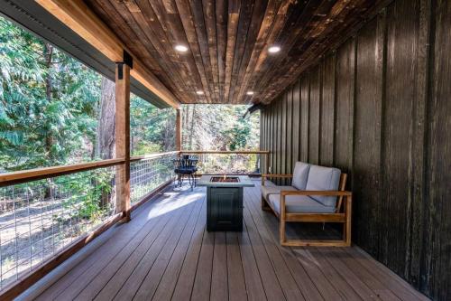 a large screened in porch with a couch and a table at Wilderness Lodge 1 bedroom cabin in the woods at Lake Wenatchee in Leavenworth