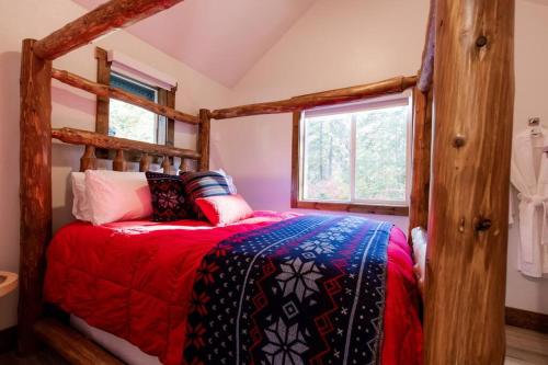 Schlafzimmer mit einem Bett mit einer roten und blauen Bettdecke in der Unterkunft Ski Chalet A cozy little cabin in the woods near Lake Wenatchee in Leavenworth