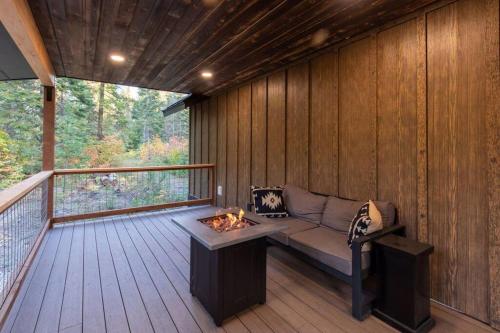 a screened in porch with a couch and a fire pit at Bear Den a Cozy 1 Bedroom tiny Cabin near Lake Wenatchee in Leavenworth