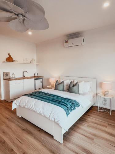 a bedroom with a white bed and a ceiling fan at Harrington Guest Suite in Harrington
