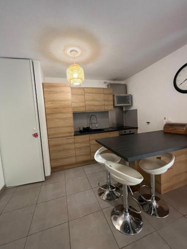 une cuisine avec une table et deux tabourets de bar dans l'établissement Vacances agréables..., à Bastia