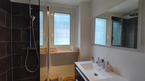 een badkamer met douche, wastafel en spiegel bij Soleil Levant - Standing T3 avec parking in Cassis