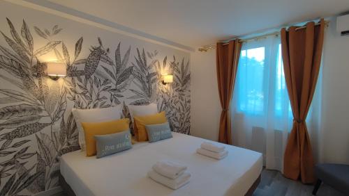 een slaapkamer met een bed met handdoeken erop bij Soleil Levant - Standing T3 avec parking in Cassis