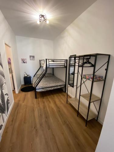 Cette chambre comprend 2 lits superposés et du parquet. dans l'établissement Le cocon de Didine, beau F2, 2 places de parking clos, proche Disneyland, à Quincy-Voisins