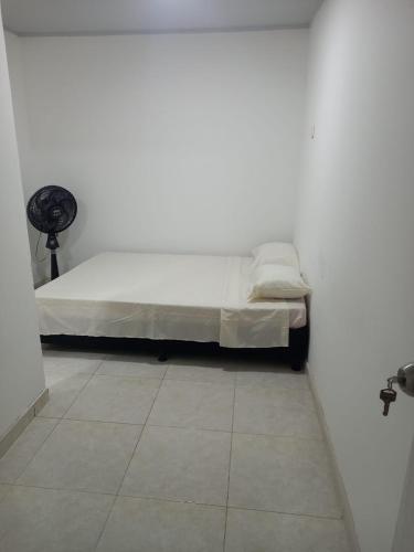 Bett in einem Zimmer mit einer weißen Wand in der Unterkunft Hotel Romadar in Puerto López