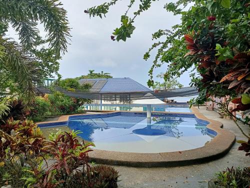 a swimming pool in a garden with a gazebo at Agta Beach Resort in Biliran