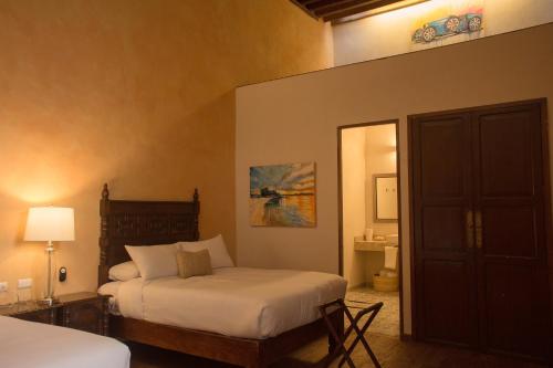 a bedroom with two beds and a door to a bathroom at Casa Montespejo B&B in Querétaro