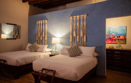 1 dormitorio con 2 camas y un cuadro en la pared en Casa Montespejo B&B en Querétaro