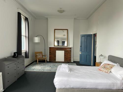 College Lawn Hotel في ملبورن: غرفة نوم بسرير وخزانة ومرآة