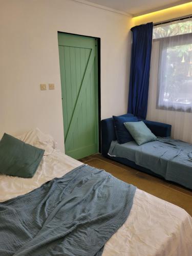 een slaapkamer met een groene deur, een bed en een raam bij Tepas Paviliun in Bandung