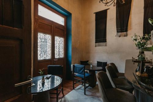a room with two tables and chairs and a door at Ya'ax Hotel Boutique in Mérida