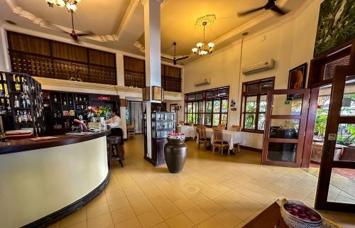 Maison Arnica Hotel & Restaurant في بنوم بنه: مطعم مع بار وغرفة طعام