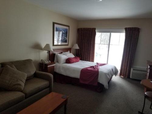 a hotel room with a bed and a couch at GetAways At Haliburton Heights in Haliburton