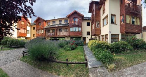 un edificio de apartamentos con jardín frente a él en Departamento centrico - 4 personas en San Martín de los Andes