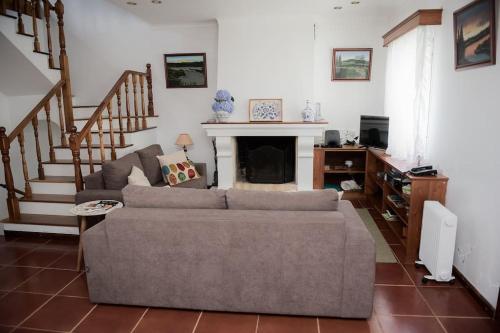 a living room with a couch and a fireplace at Casa das Hortênsias - Beach House in Porto Formoso