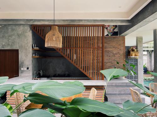 a living room with a staircase and plants at Griya tropical in Ubud