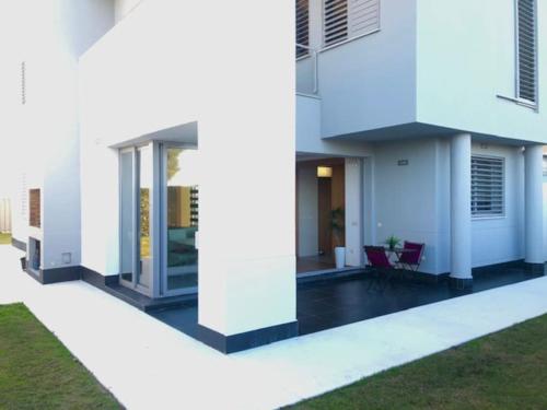 a white house with a courtyard with a table and chairs at Modern Zen Bali in Puerto Real