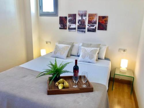 a bed with a tray with a bottle of wine and fruit at Modern Zen Bali in Puerto Real